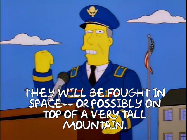 Simpsons military academy guy voiced by Willem Dafoe at a podium going on where the wars of the future will be fought. “They will be fought in space, or possibly on top of a very tall mountain.”