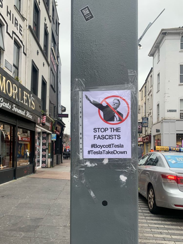 A DIY poster of Musk doing his nazi salute with a prohibited sign over him. The poster reads stop de fascists and the hashtags boycott Tesla and Tesla take down. Poster is on a post in cork city centre, Ireland. 