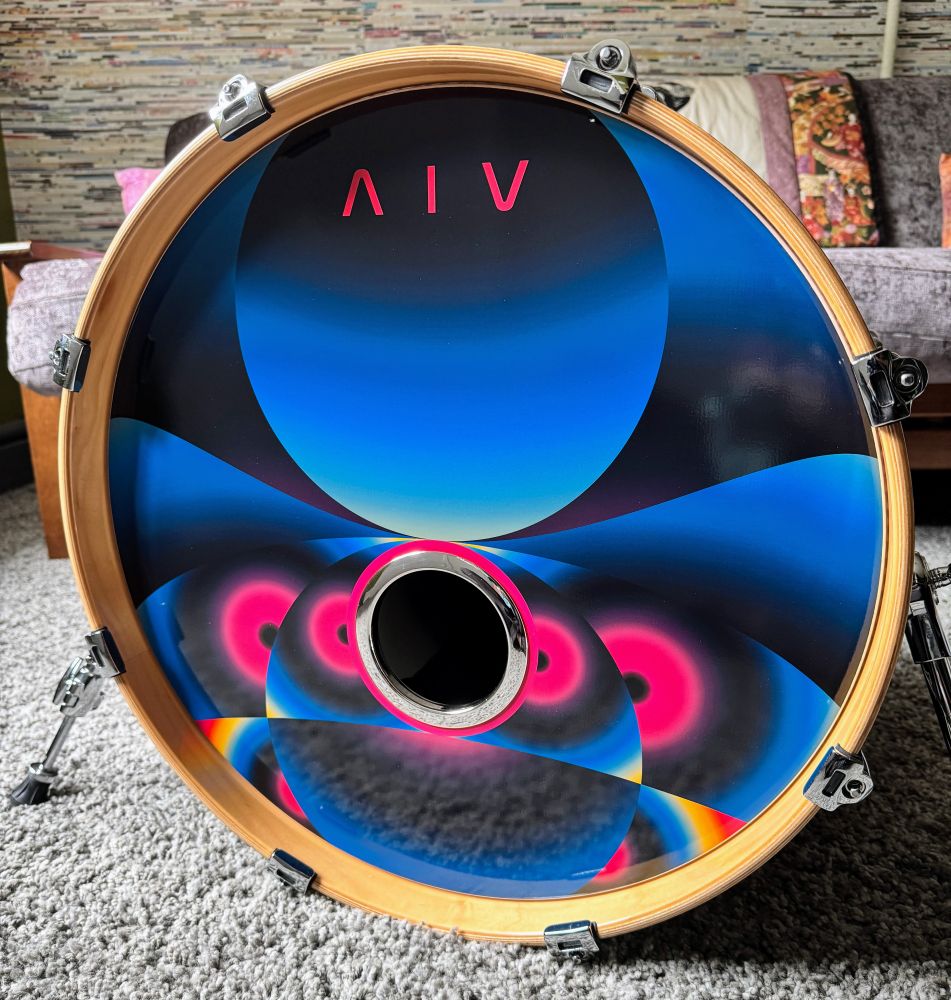 20" kick drum with drum head art that features the Delta IV logo overlayed on top of futuristic, abstract interwoven circles of different vibrant colors.  