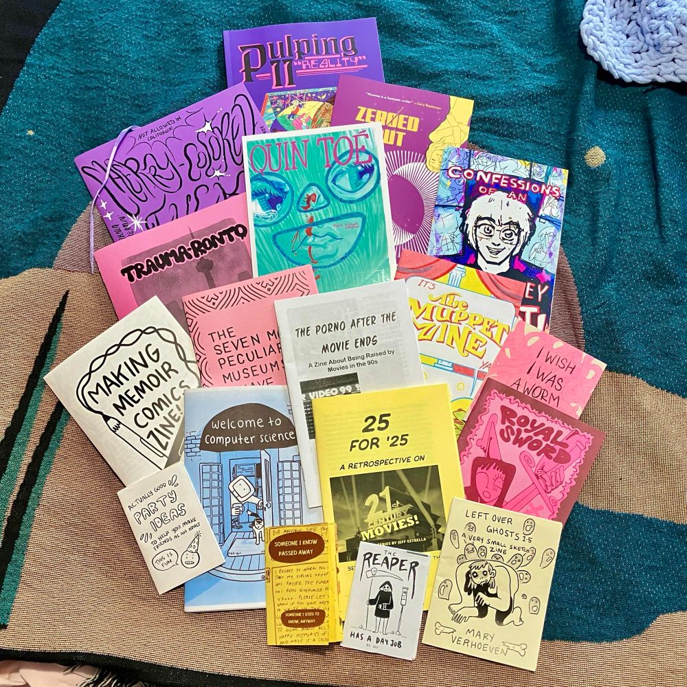 Flatlay of comics and zines including
Confessions of an Artist Alley Burnout by Zeekayart
Leftover Ghosts by Mary Verhoeven 
Zeroed Out by Jim Monroe & Eric Kim
The Seven Most Peculiar Museums I Have Visited by Allison O’Toole