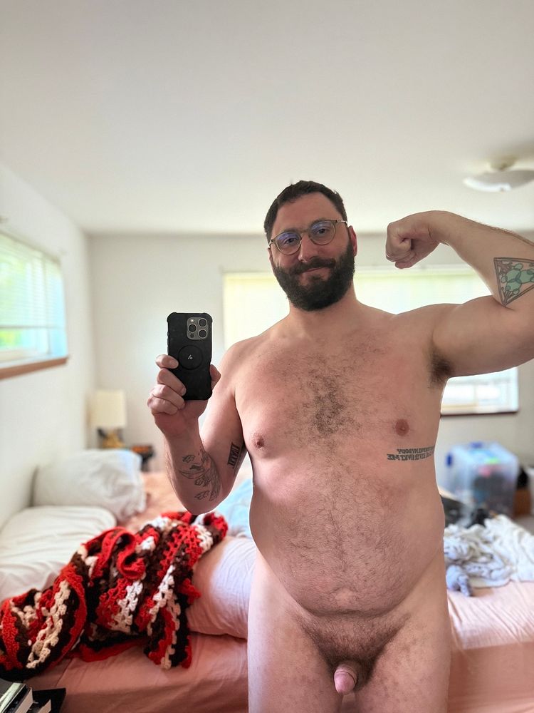 Naked mirror selfie in a sunny room. I’m flexing my left arm.