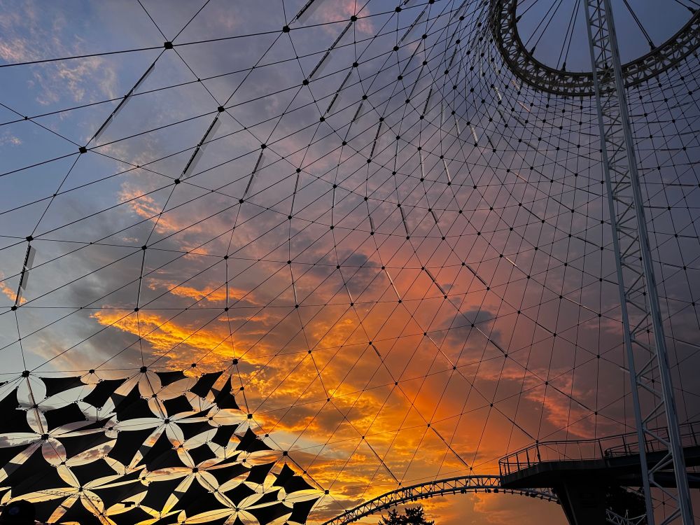Orange coral sunset through the wires of the Spokane pavilion 
