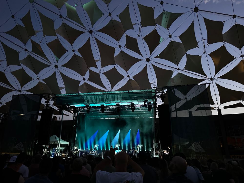 Death can for cutie on stage with green lights and framed by the Spokane pavilion sails