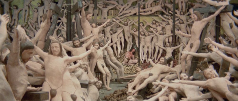 The thief shrieking in anger as he's surrounded by an infinite amount of wax status of himself as Christ on the cross