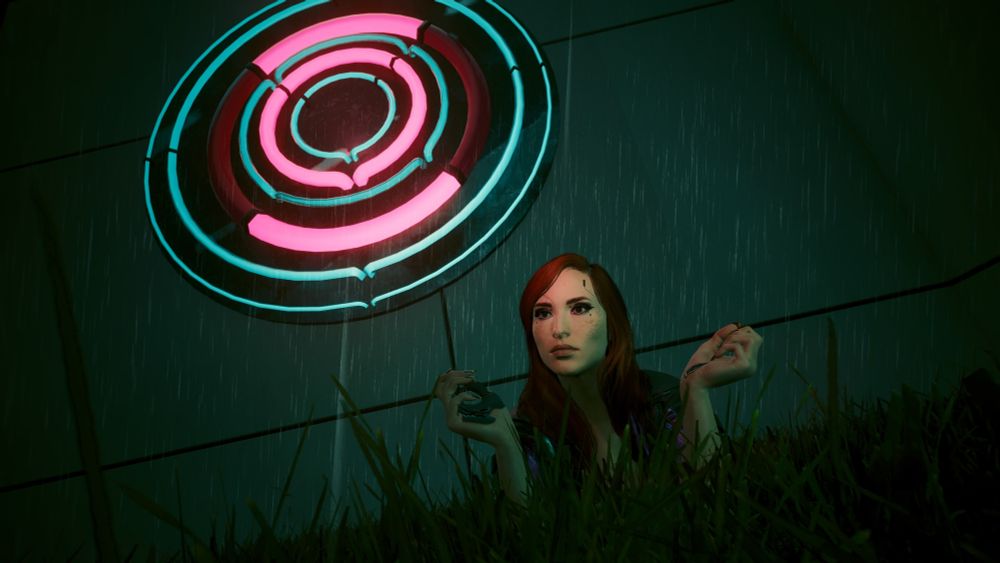 Little round pink-blue sign that appears mostly in nicer, more corpo areas glows in a rainy night. Below, V lies in the grass despite the rain, lit from above by the neon carried in the rain. Peak manic Pixie activities. 