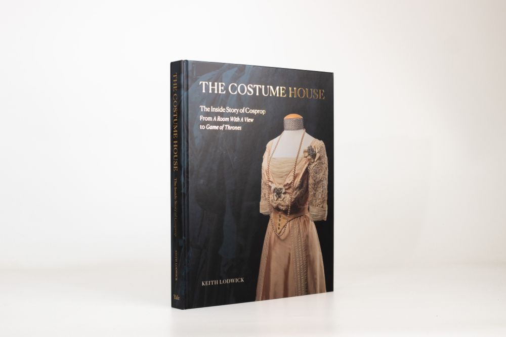 Photo of 'The Costume House' book which shows a peach period style dress on the cover against a dark blue background
