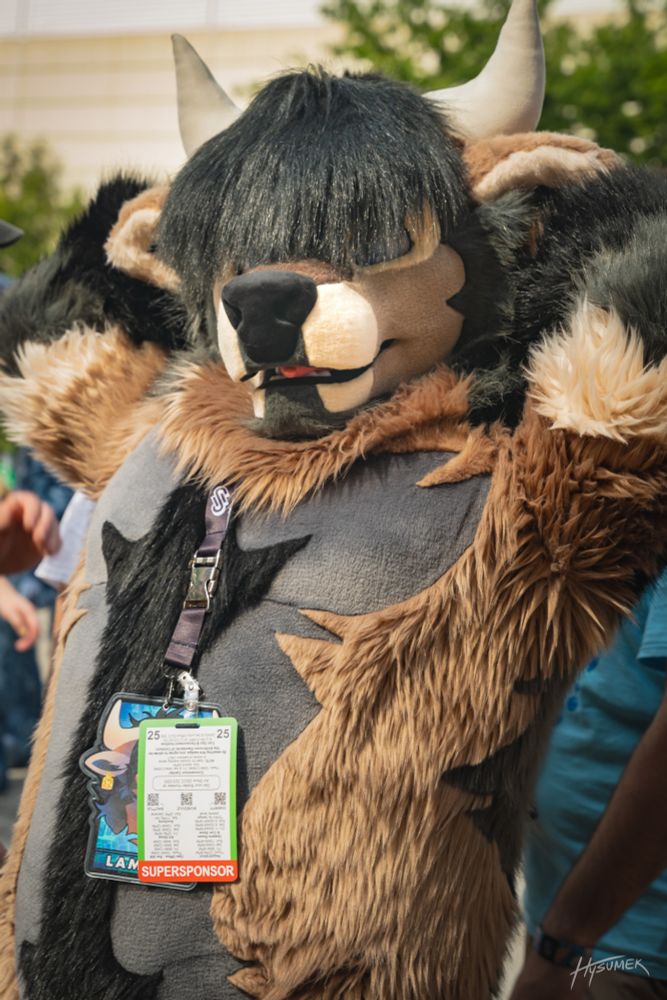 Earth colored bull fursuiter with his arms behind his head