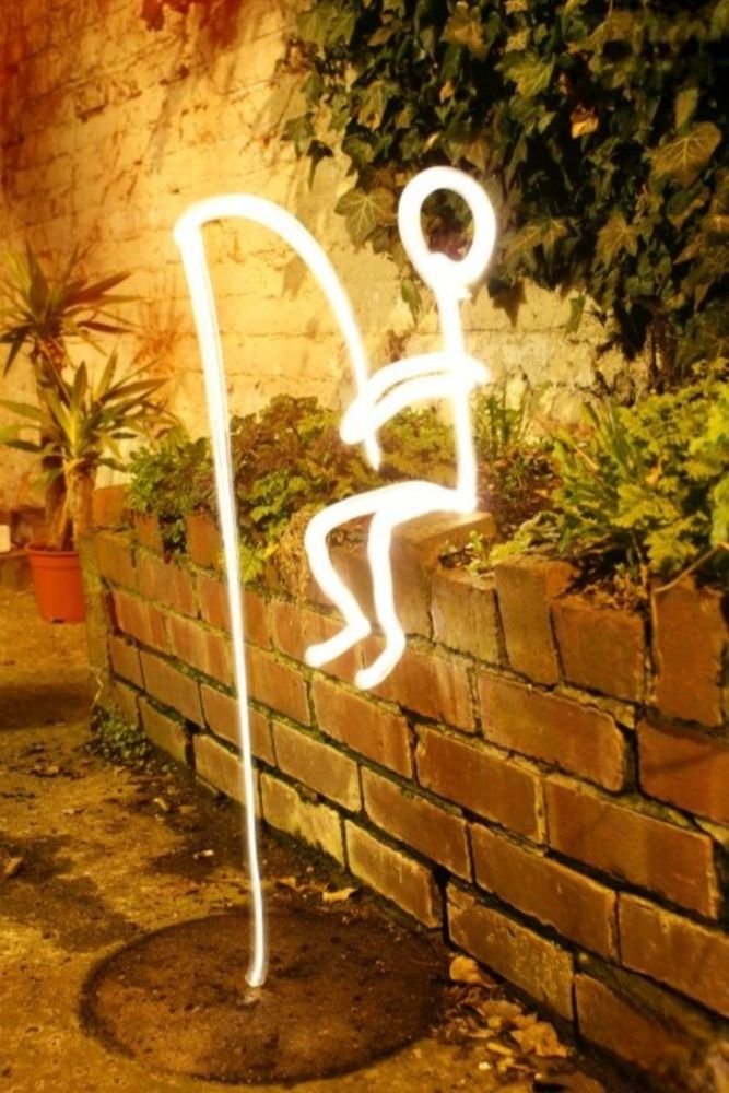 Photo, plaque d'égout, rue début de soirée ambiance couleur orangé.
En montage ajouté, un bonhomme assis sur le bord d'un muret, fluorescent jaune, muni d'une canne à pêche reliée à la plaque d'égout. Dessiné en traits simple.

Je crois que nous sommes en présence d'une tentative de raccourci pour rejoindre le week-end prochain...

Belle et douce soirée.✨️