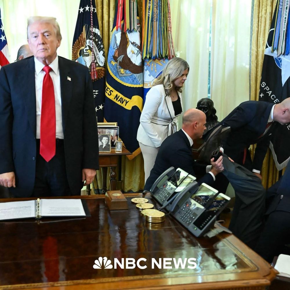 Trump stands, seeming almost paralyzed, as many others in the oval office rush to the aid of a man who has collapsed.