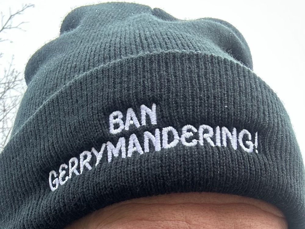 Knit hat with the words “Ban Gerrymandering!” embroidered on it.