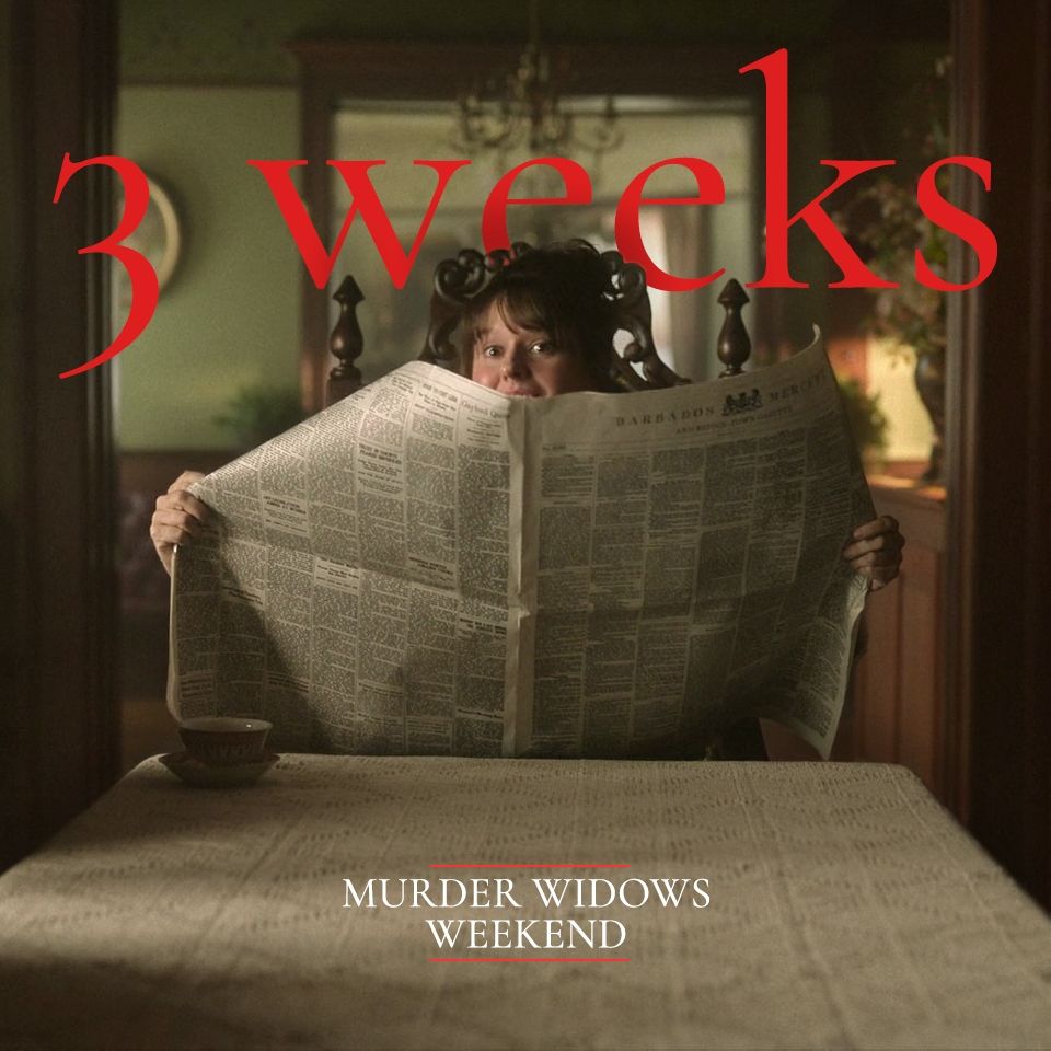 Mary from OFMD is looking at the camera from behind a big unfolded newspaper. The text in red, overlaid as if it were behind her, reads: "3 weeks". On the bottom the text in white reads "Murder Widows Weekend"
