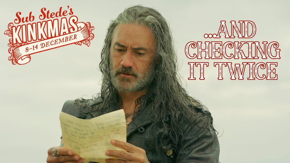 A photo of Edward Teach looking damp with his hair down and wearing his leather jacket. He's holding and reading a letter from Stede (a scene from season 2 episode 8 of OFMD).

In the top left corner is the Sub Stede's Kinkmas (8-14 December) logo. To the right it reads '...And checking it twice'