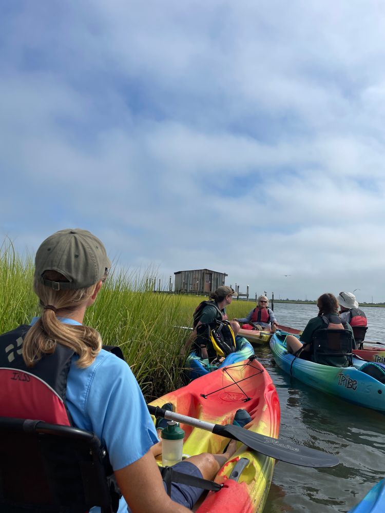 Listening to a ranger talk. Bow of a kayak in Rehoboth Bay
