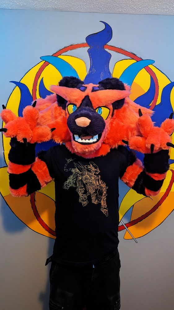 Varium the Incineroar suit. He's a grapefruit and purple Incineroar with striped arms, big paws, and even bigger cheek fluffs! 
Fursuit made by Saros Suitworks - 2025