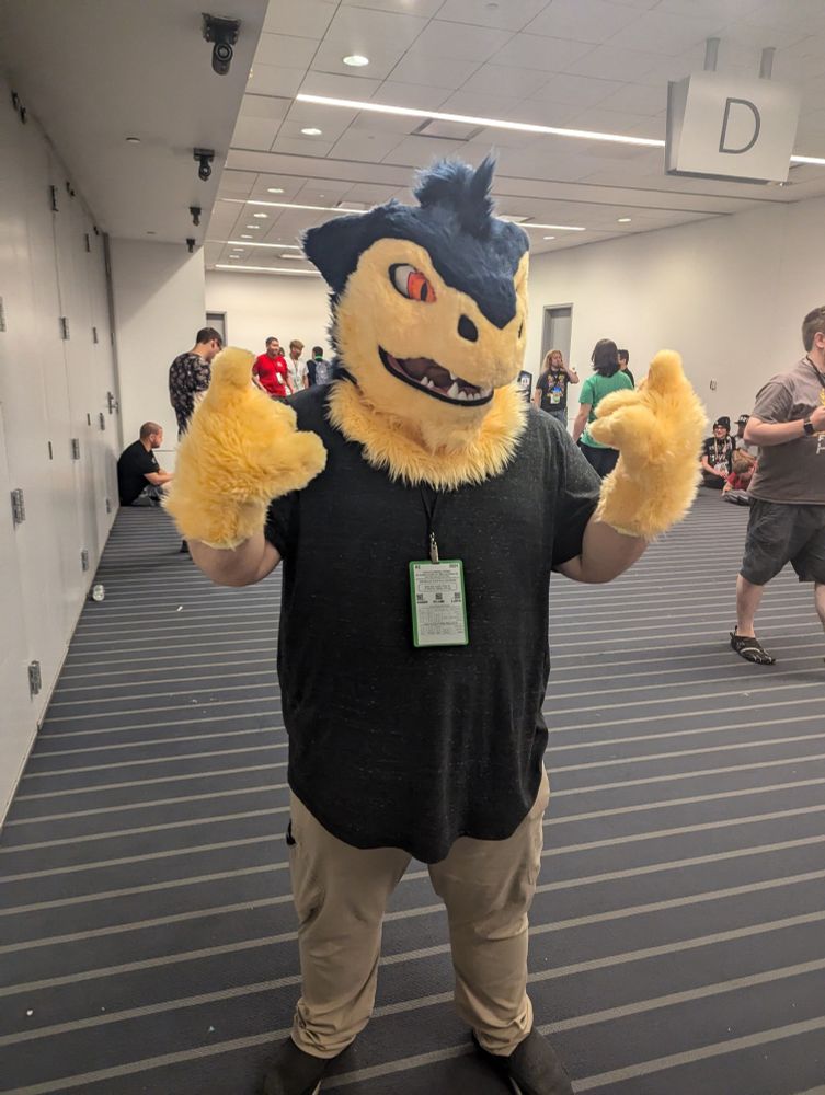 Flaze the Typhlosion! This is a photo of the suit's owner right after he was given his fursuit at AnthroCon 2024! Flaze is ready to rock! Using both his hands, he's throwing up the horns 🤘🤘