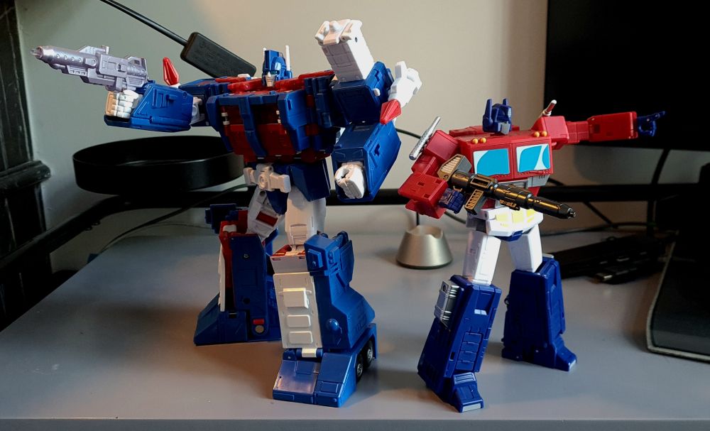Photo graph of the new transformers figures Ultra Magnus (left a blue red and white anime style robot) and Optimus Prime (right, a smaller red blue and white anime style robot)