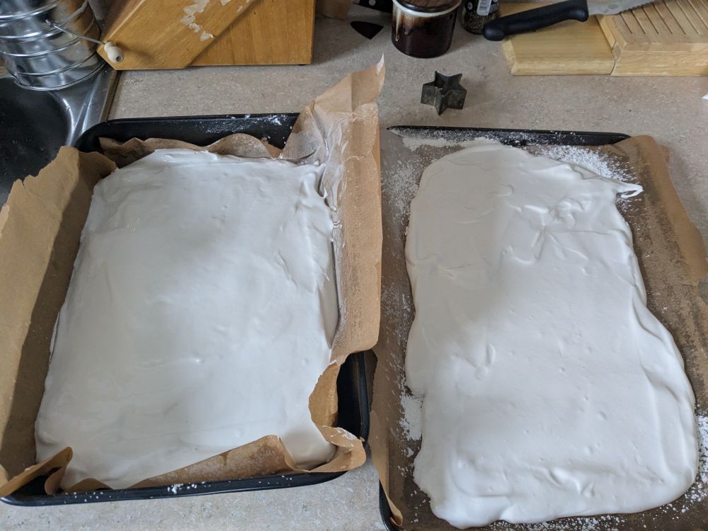 two trays of marshmallow spread out, one deep and one in a thin layer