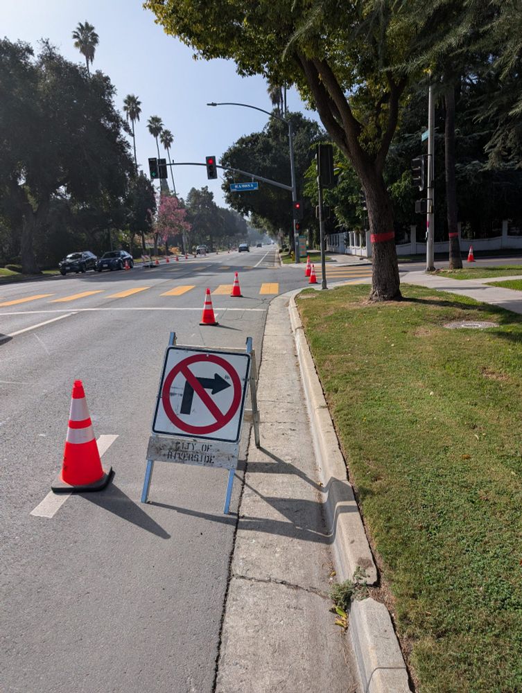 A construction sign saying no right turn in the middle of a bike lane. Traffic cones further block the lane