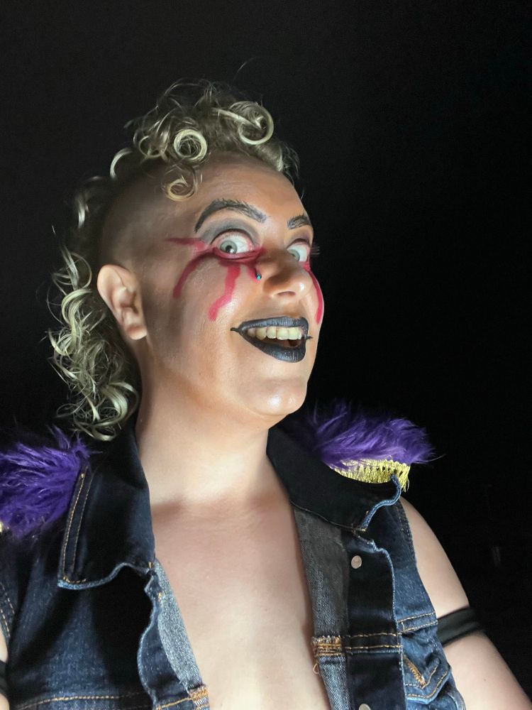 Crybaby in their bloody tear makeup and denim entrance vest