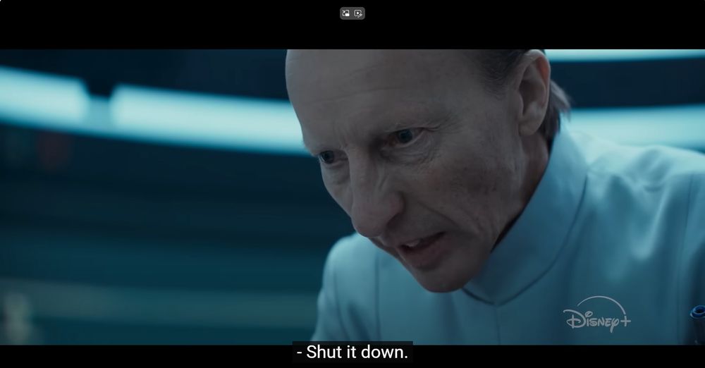 A scene from Andor. Supervisor Lagret (an imperial intelligence officer in a white uniform) says "Shut it down" through gritted teeth.