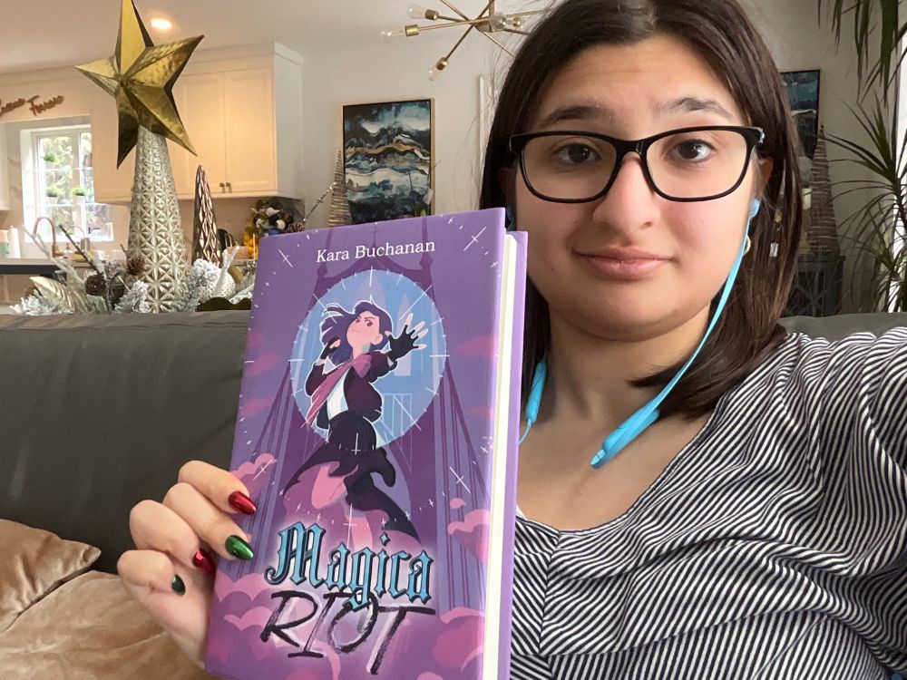 Me holding up the Magica Riot Book when it finally arrived in the mail!