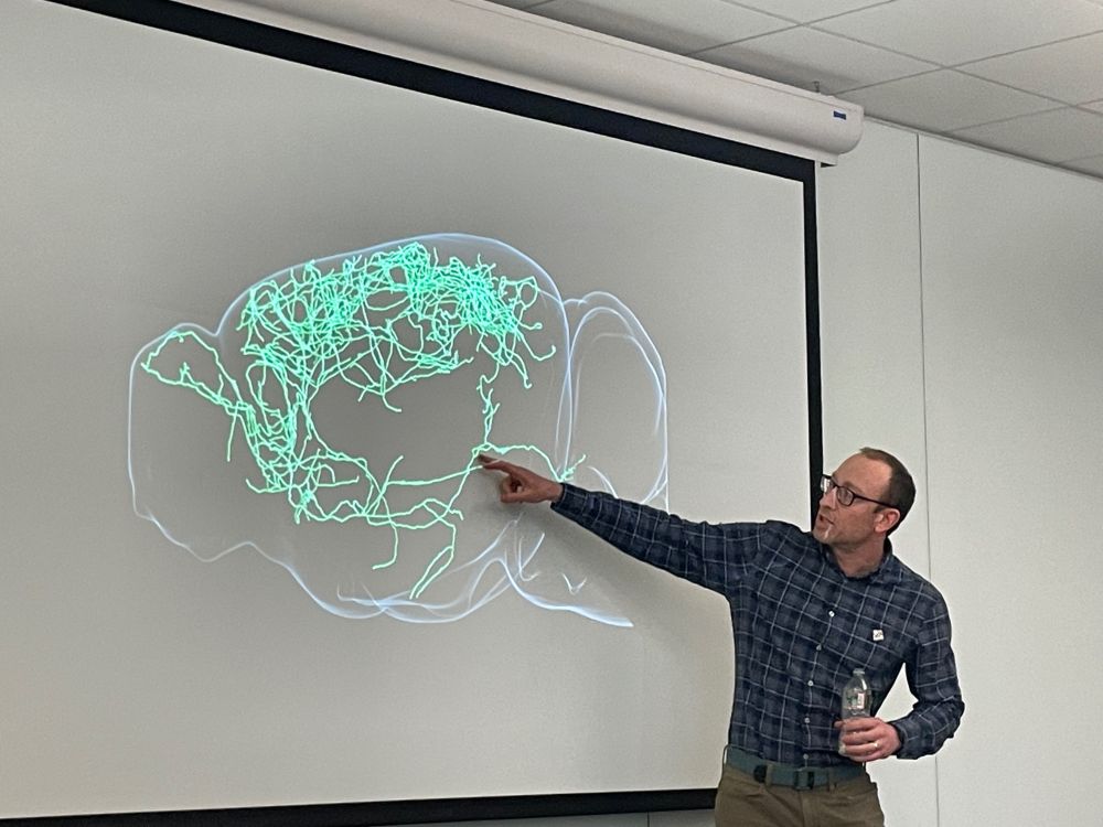 Jeremiah Cohen standing in front of a giant green neuron.