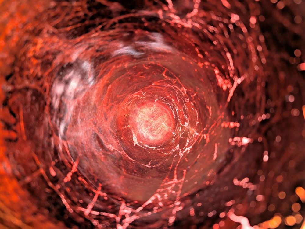 The inside of a copper colored vase. The camera is positioned on the inside such that you only see the center, hiding the fact that it's a vase. The light shining on the outside illuminates the inside, making it seem like a funnel shaped storm.