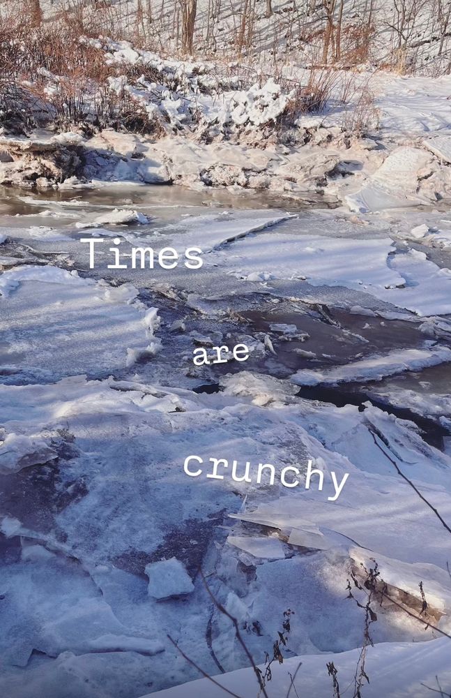 Crunchy ice gathers in chaotic formations atop the Jijiwuktuk river. There is text superimposed on the scene saying “times are crunchy” 