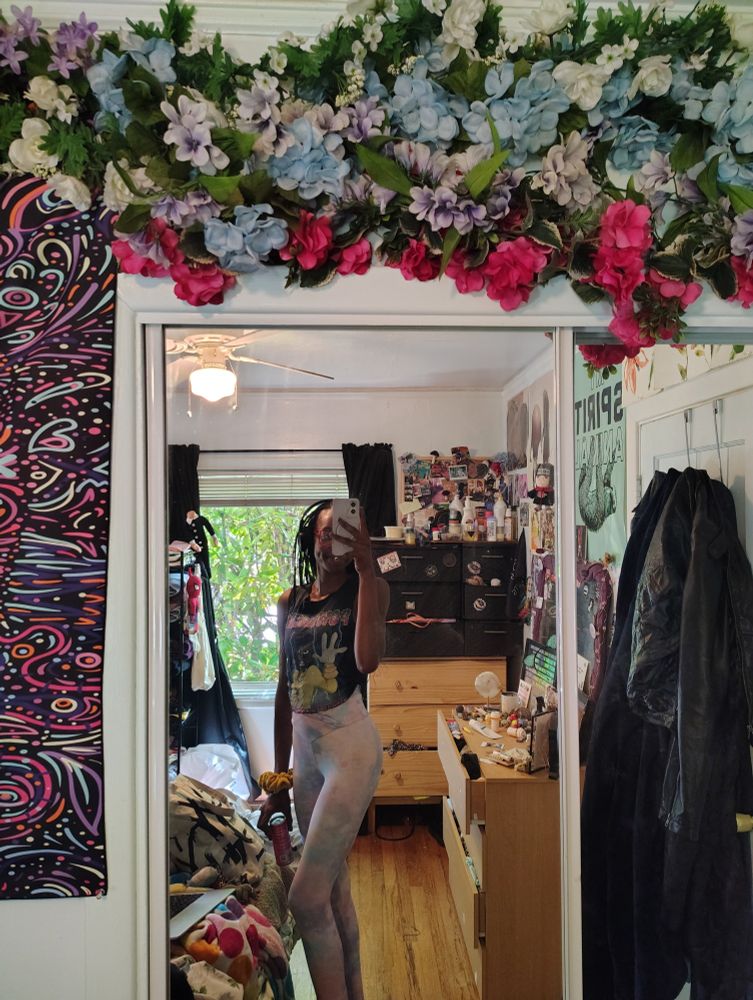 Mirror selfie of a woman in pink and blue tie dye leggings and a Powerline tshirt