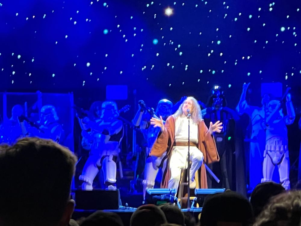 Picture from a Weird Al Yankovik this August in South Lake Tahoe. He is performing the song 'Yoda', dressed like a Jedi with Storm Trooper costumed band members behind him and a starry-sky like background projected on the background screen.