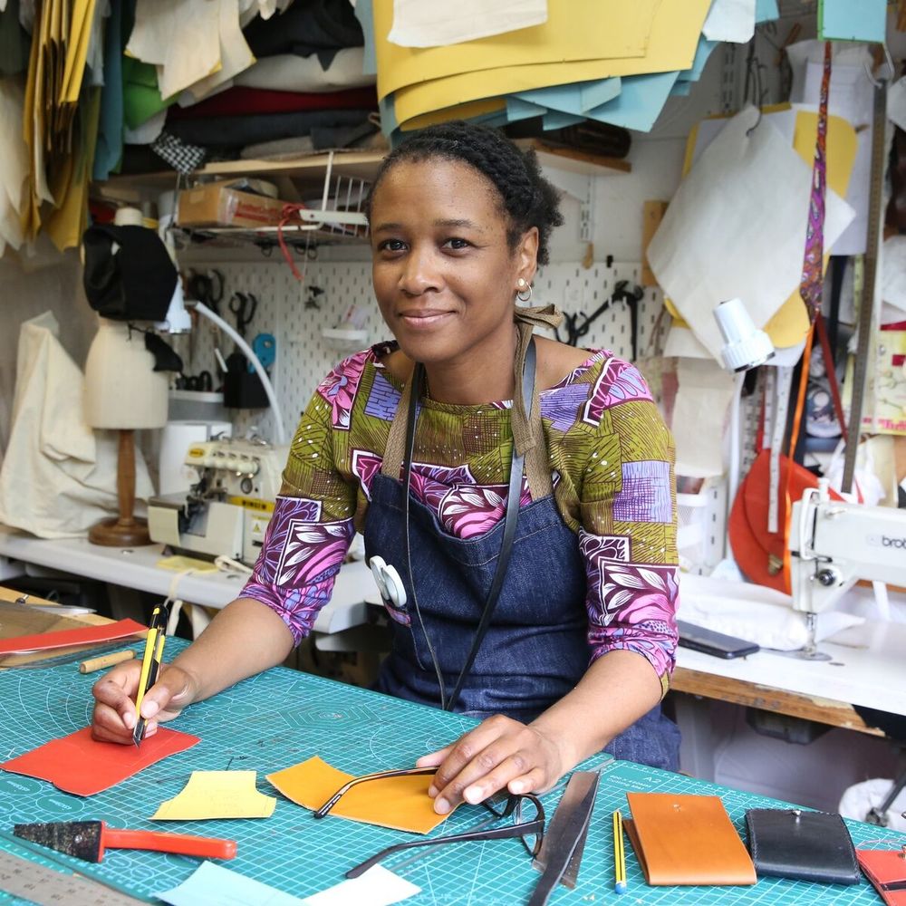 Person at a desk, they ae holding a pencil and looking at the camera. 