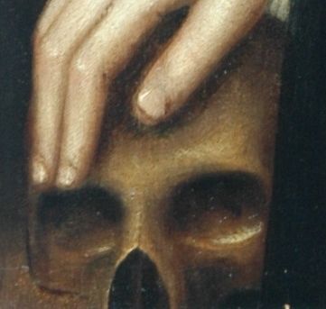 We are looking at a close up of an oil painting showing a man resting his hand on a brown coloured skull. It's only the top part - it is missing its jaw. 