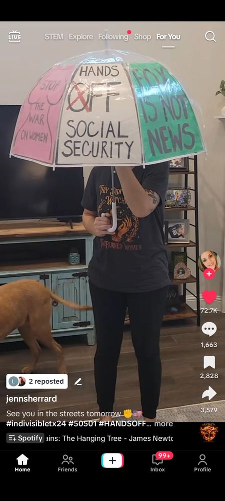 Lady holding an umbrella that is her protest sign 