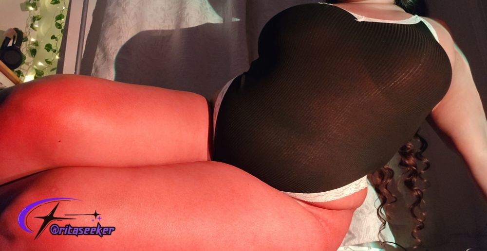 ser is laying on her side wearing a black bodysuit <3