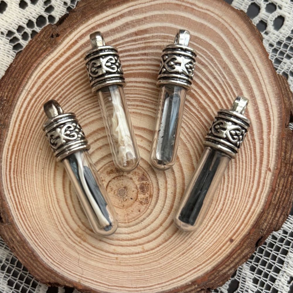 Tiny vials, some with bones from owl pellets, some with vivianite and clear quartz. 