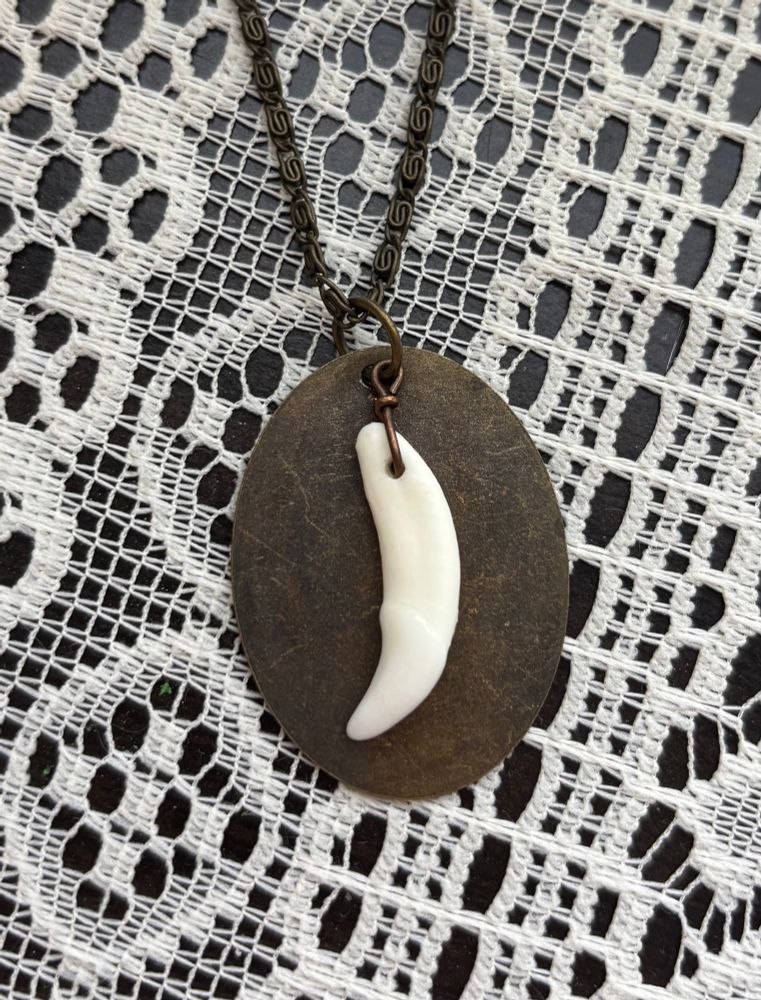 A brass and coyote tooth necklace. 