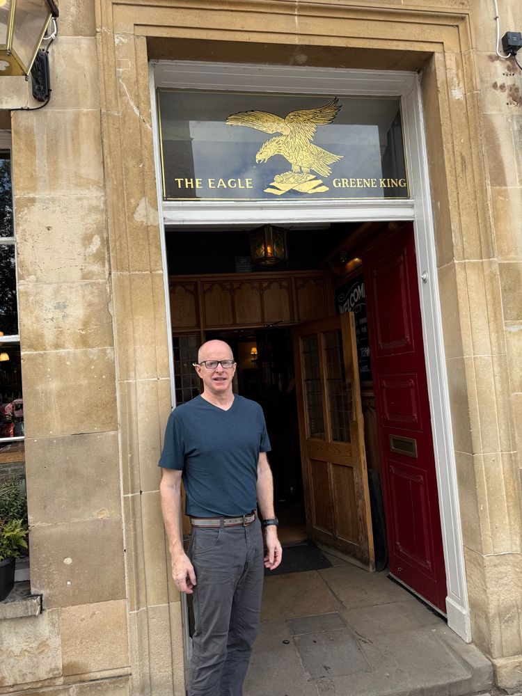 Old bald white guy outside the Eagle Pub in Cambridge, England