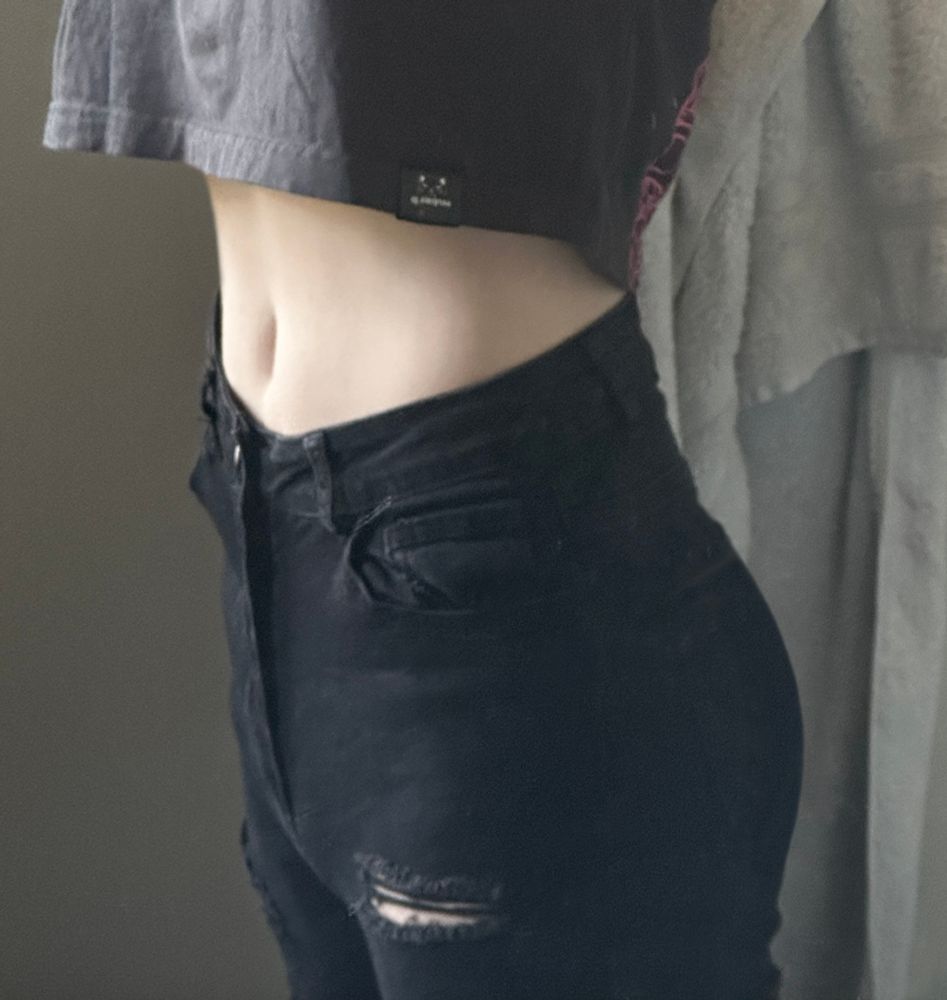 An image of myself wearing a croptop and ripped skinny jeans, with my tummie exposed