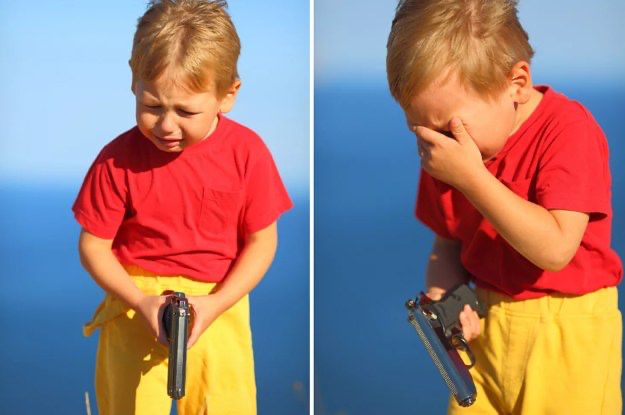 kid in a red shirt and yellow shorts holding gun while crying