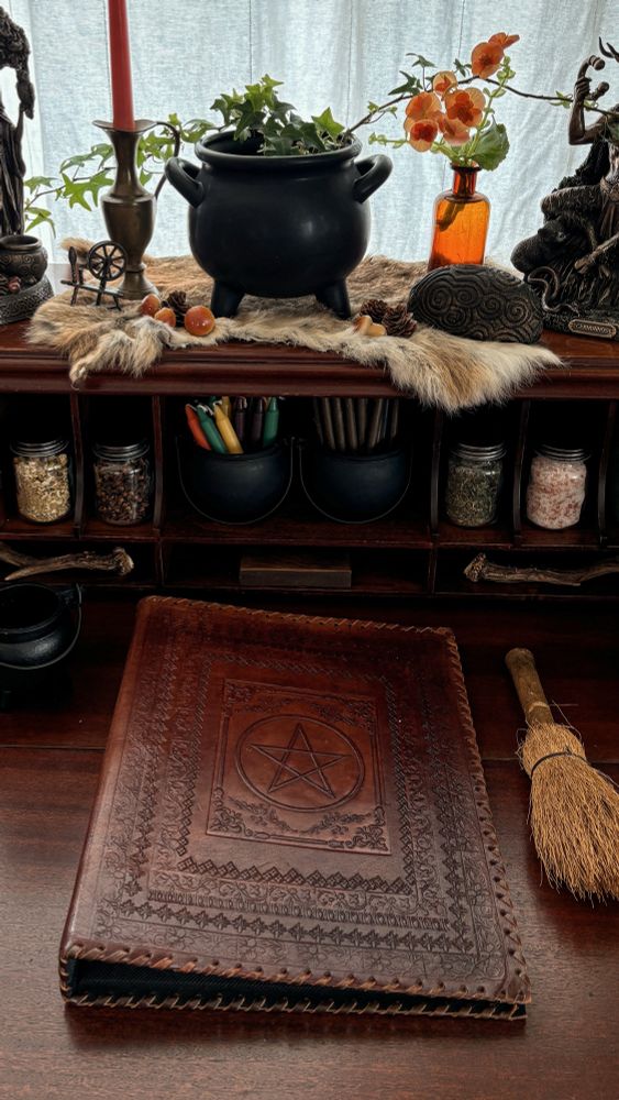 Photo of a witches altar with a leather book of shadows and candles