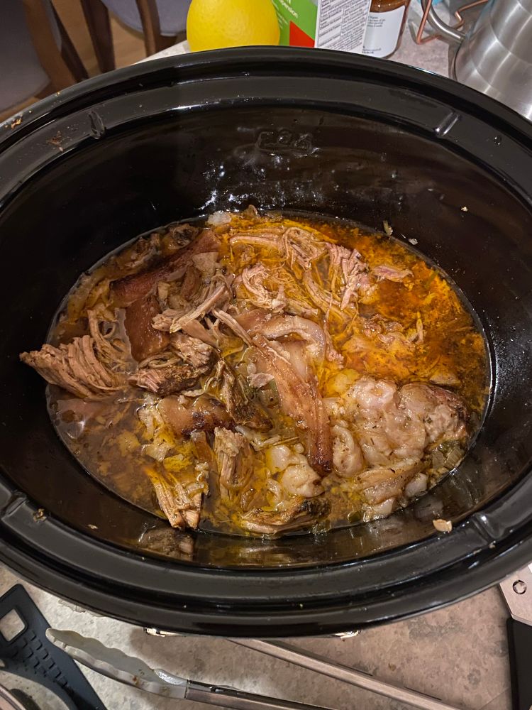 Slow cooker dish with carnitas after being cooked for 10 hours. Basically melted apart. 