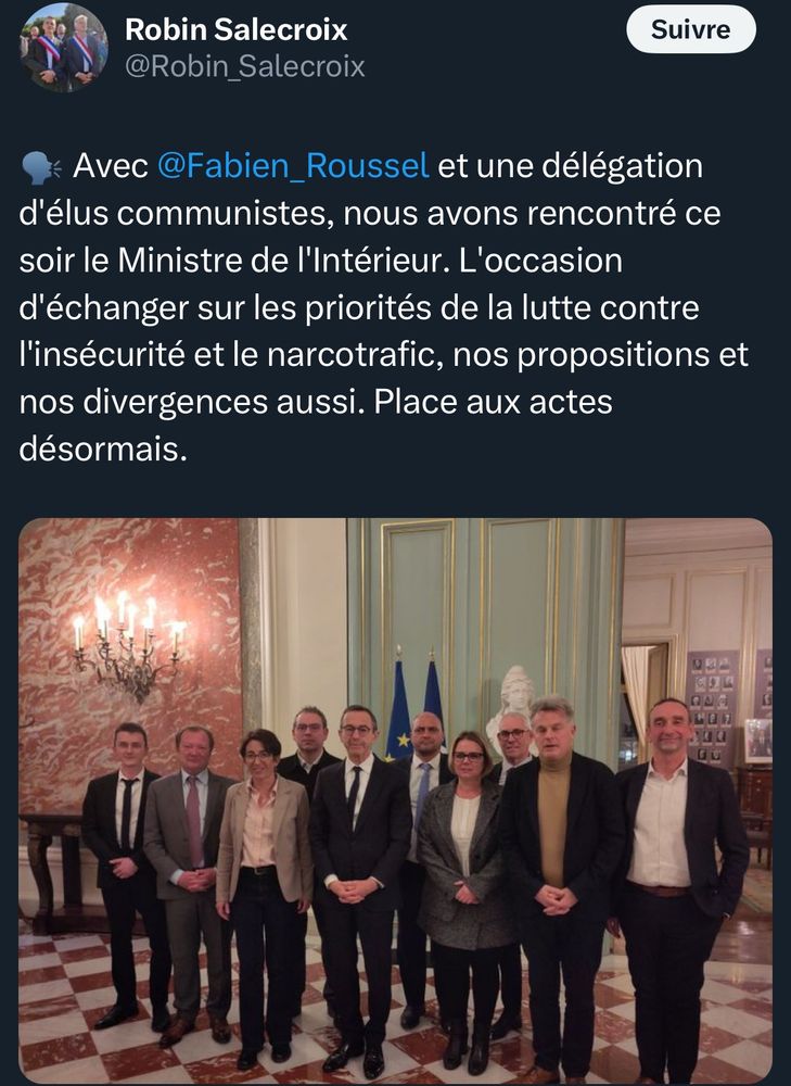 Capture d’écran d’un tweet de Robin Salecroix annonçant une rencontre entre Fabien Roussel, une délégation d’élus communistes et le Ministre de l’Intérieur Bruno Retailleau. Le tweet mentionne un échange sur la lutte contre l’insécurité et le narcotrafic, ainsi que les propositions et divergences des participants. En dessous du texte, une photographie montre un groupe de dix personnes posant dans une salle ornée, avec un sol en marbre, des murs décorés et deux drapeaux, dont celui de l’Union européenne, en arrière-plan. La plupart des participants portent des tenues formelles (costumes, vestes), et un buste est visible derrière eux.