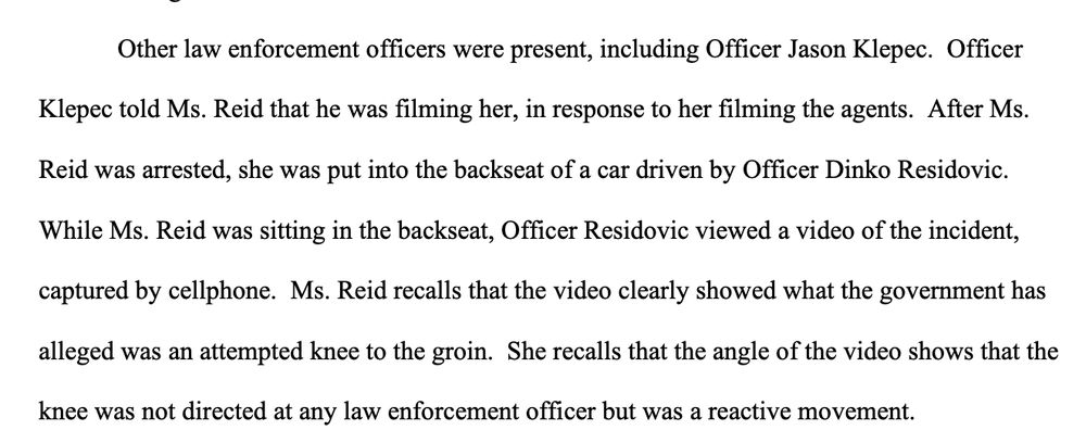Other law enforcement officers were present, including Officer Jason Klepec. Officer
Klepec told Ms. Reid that he was filming her, in response to her filming the agents. After Ms.
Reid was arrested, she was put into the backseat of a car driven by Officer Dinko Residovic.
While Ms. Reid was sitting in the backseat, Officer Residovic viewed a video of the incident,
captured by cellphone. Ms. Reid recalls that the video clearly showed what the government has
alleged was an attempted knee to the groin. She recalls that the angle of the video shows that the
knee was not directed at any law enforcement officer but was a reactive movement.