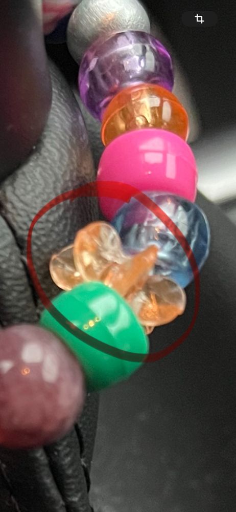 Screenshot von einem selbst gefädelten Armband mit bunten Perlen, darunter eine Art Rädchen.