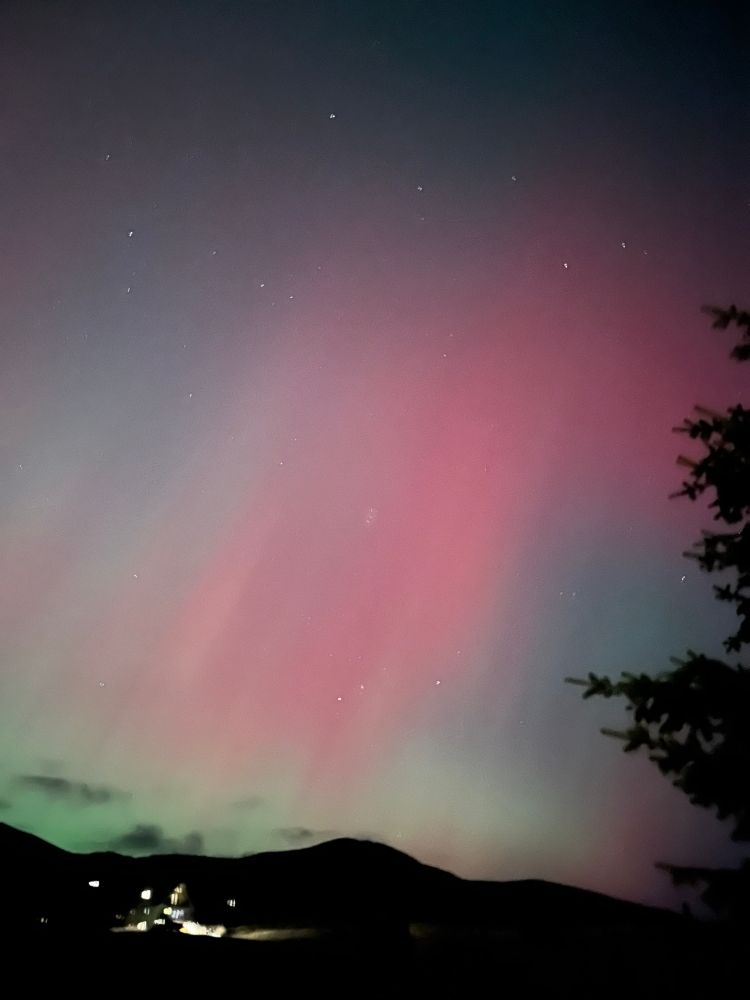 Photo of Northern Lights with red, pink, green, blue, and yellow colors.