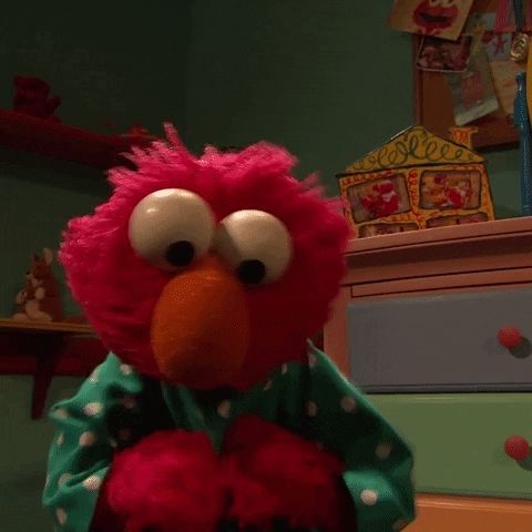 Elmo doing a happy dance in his pajamas.