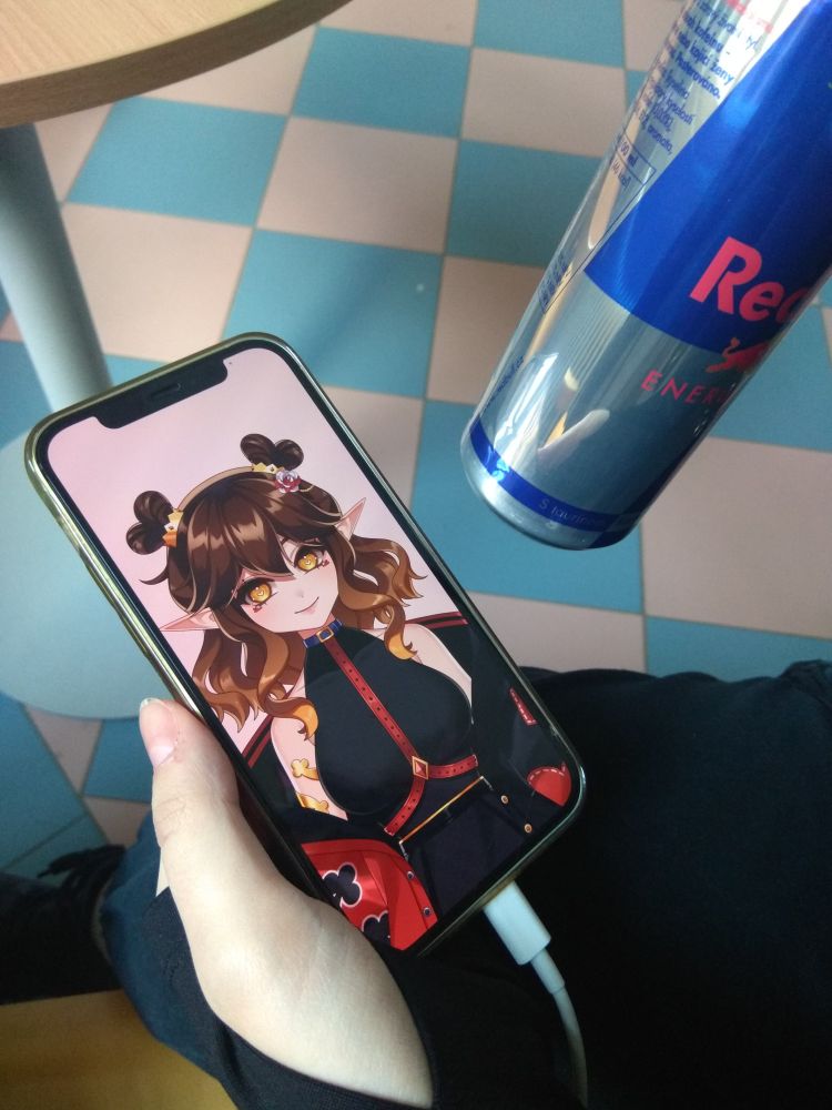 Photo of Acey on a phone screen with a can of red bull next to her!