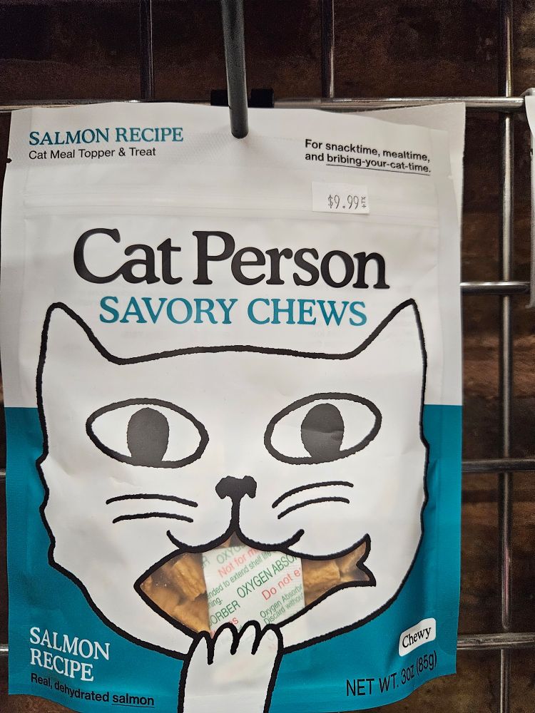a treat bag with a drawing of a cat on the front that looks like its going to eat a silica packet
