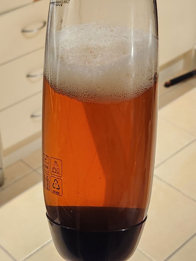 a sodastream bottle filled with carbonated, lightly flavoured red tea