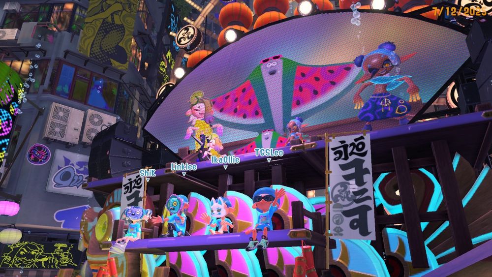 Screenshot from Splatoon 3: my inkling and TSGLeo’s octoling are posing on the Splatfest float